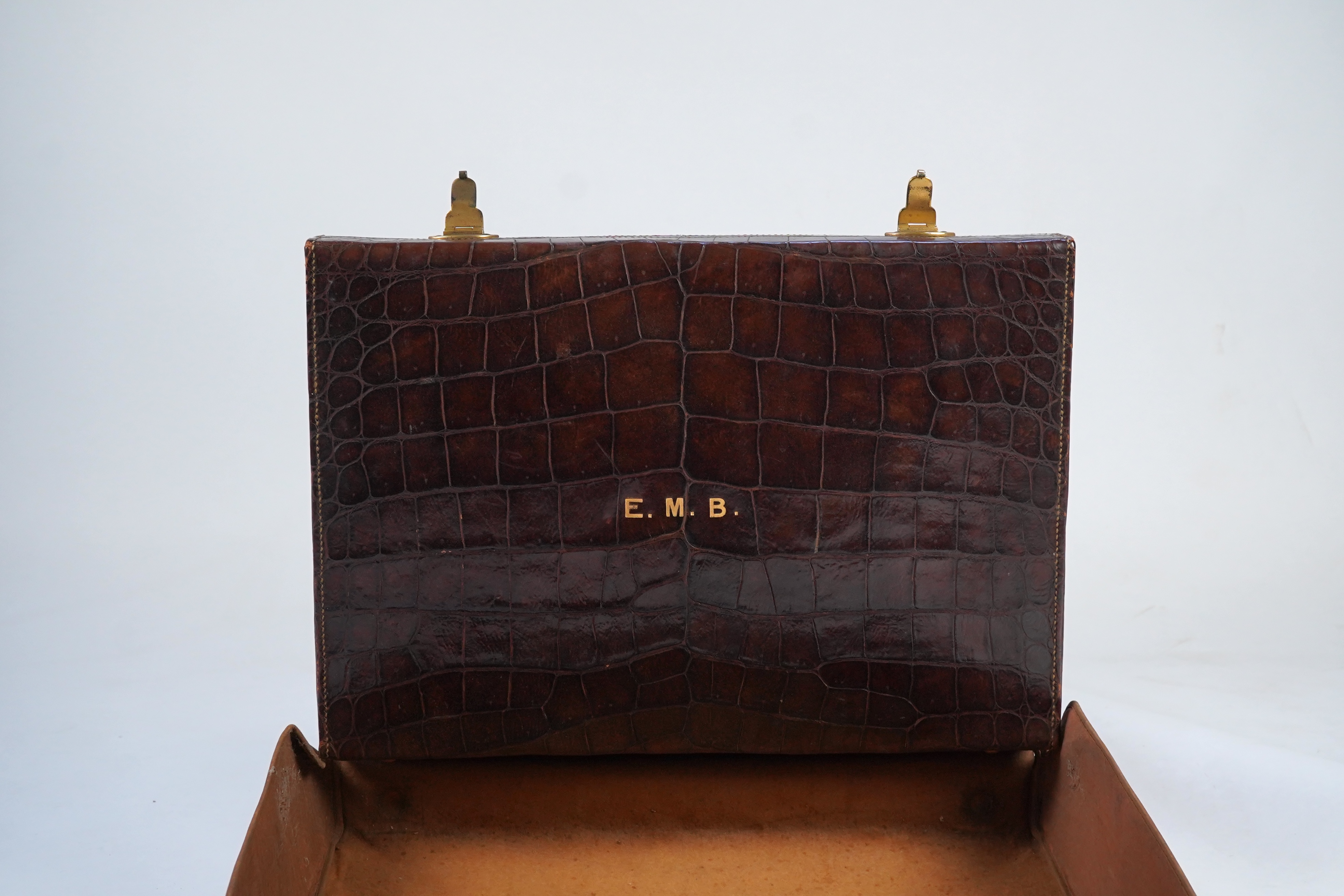 A George V crocodile skin travelling toilet case, containing twelve silver and tortoiseshell mounted accoutrements, by Collet & Anderson